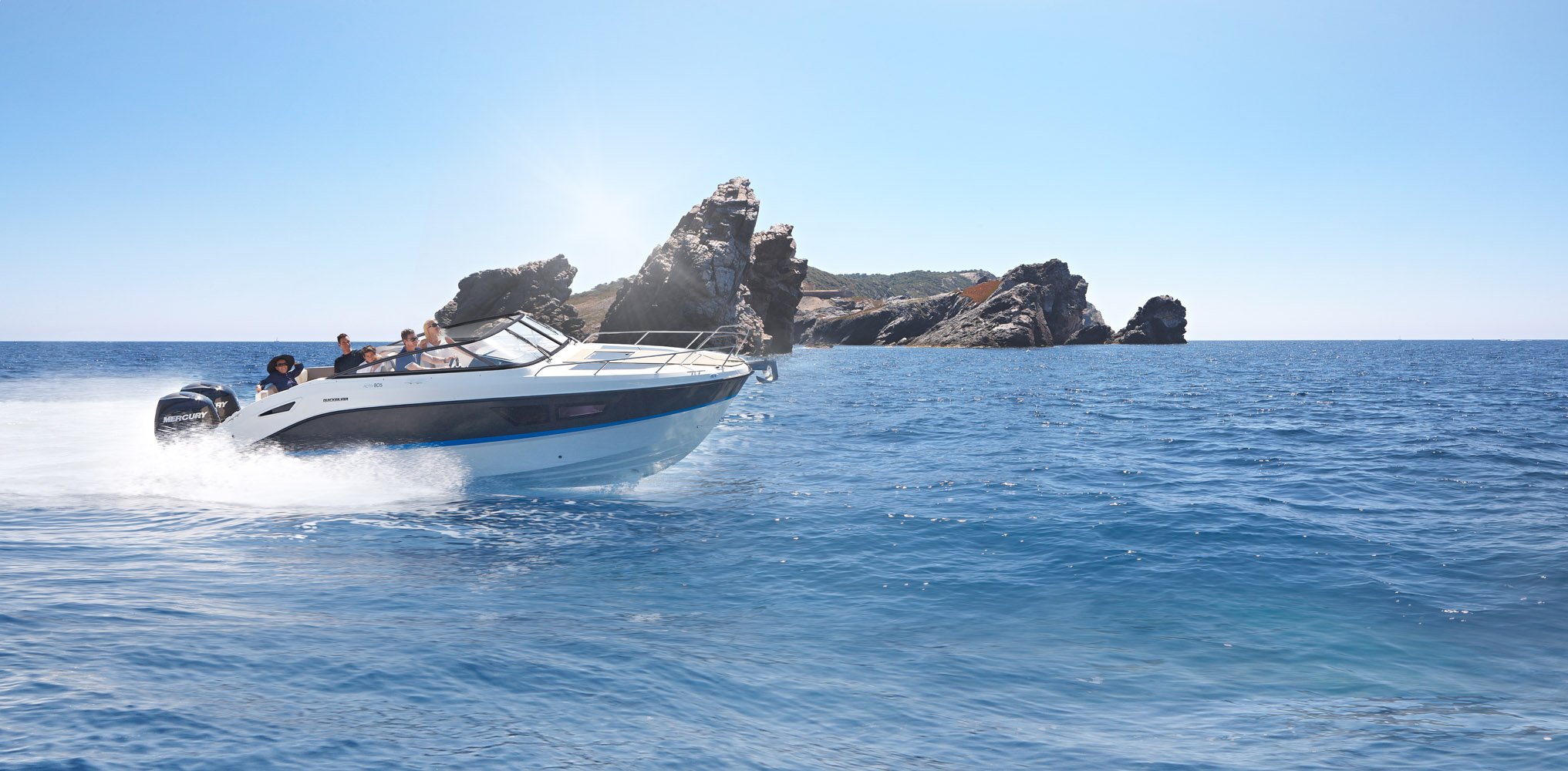 Activ 805 Cruiser sweeping past a sea stack