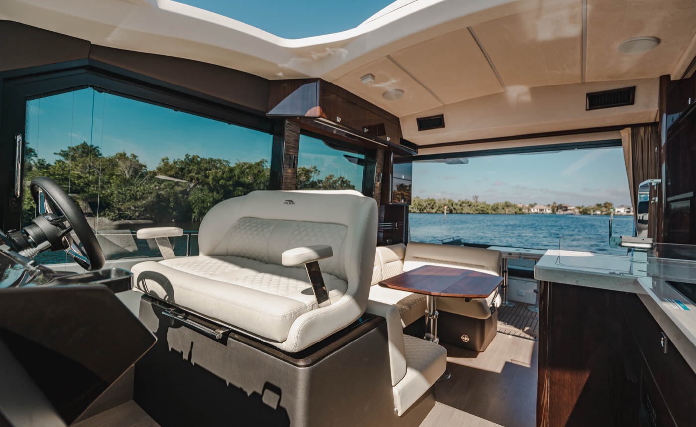 410 HTC helm area: white helm seat, open sunroof and light-filled saloon