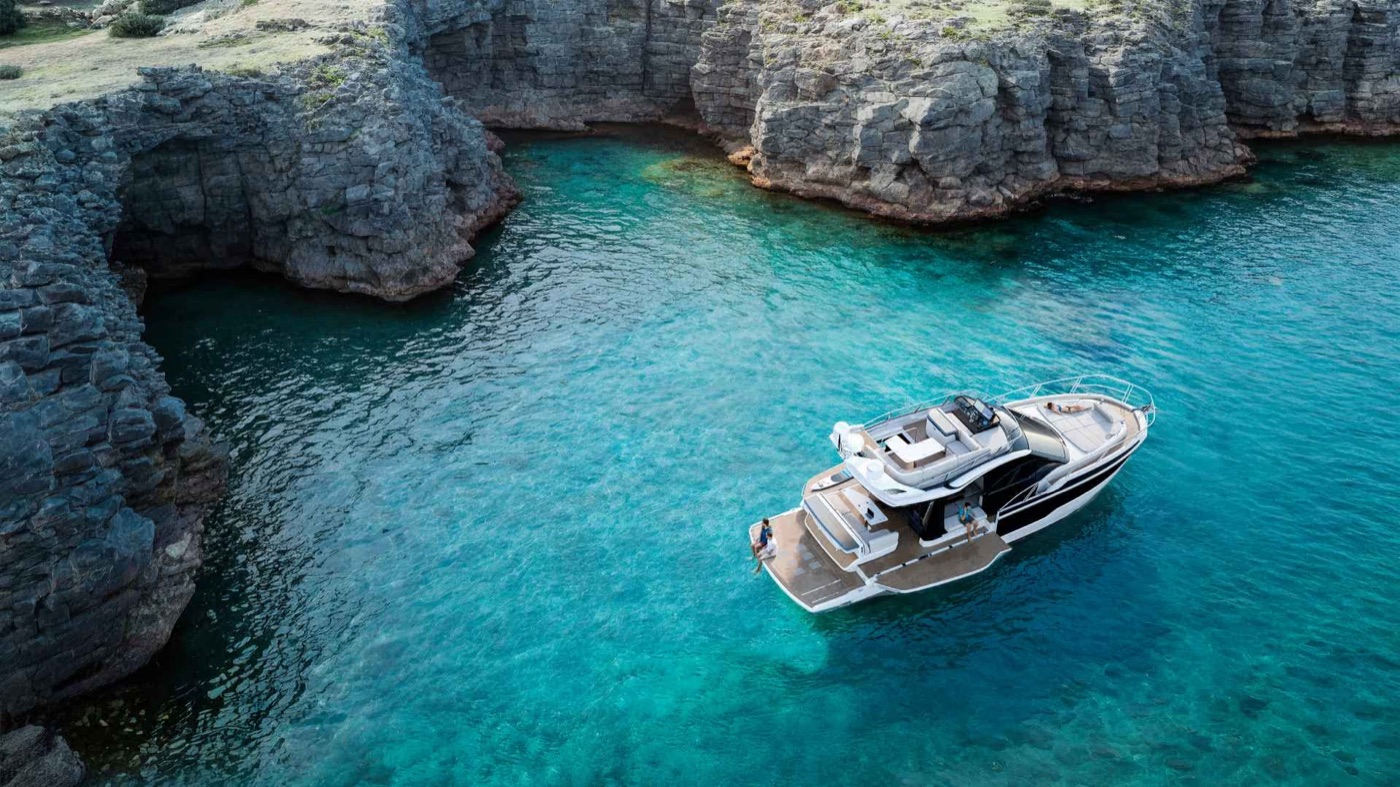 420 FLY at anchor in a turquoise cove ringed by cliffs