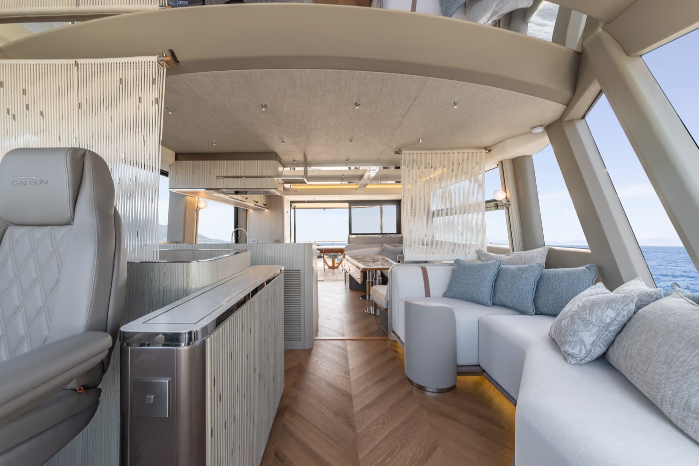 620 FLY main salon: open galley, L-shaped sofa and helm in one flowing space