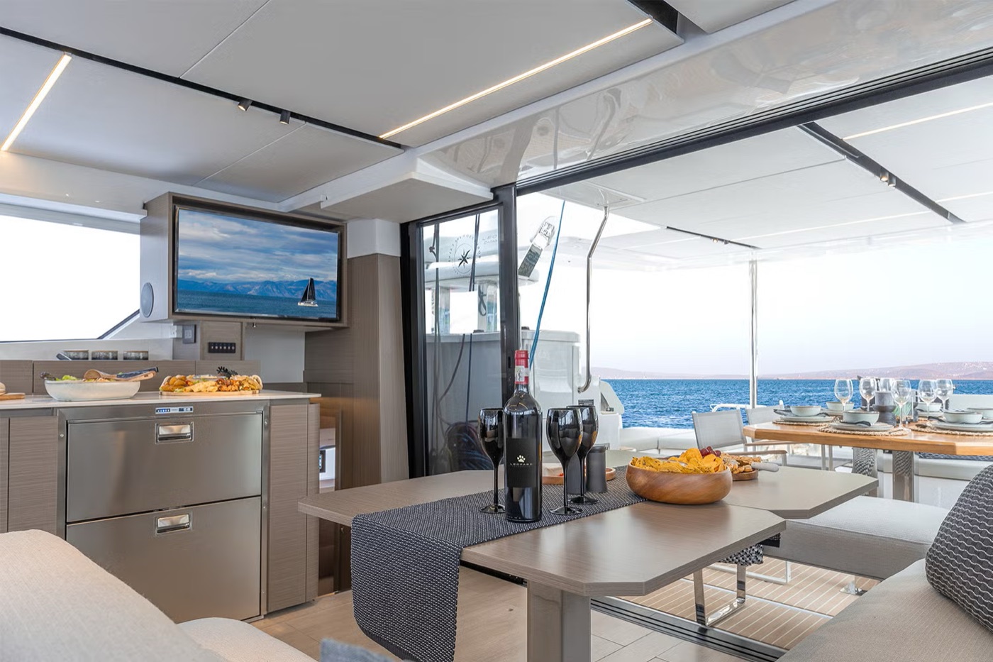 Aerial stern view: hardtop solar panels, flybridge helm and teak swim platforms