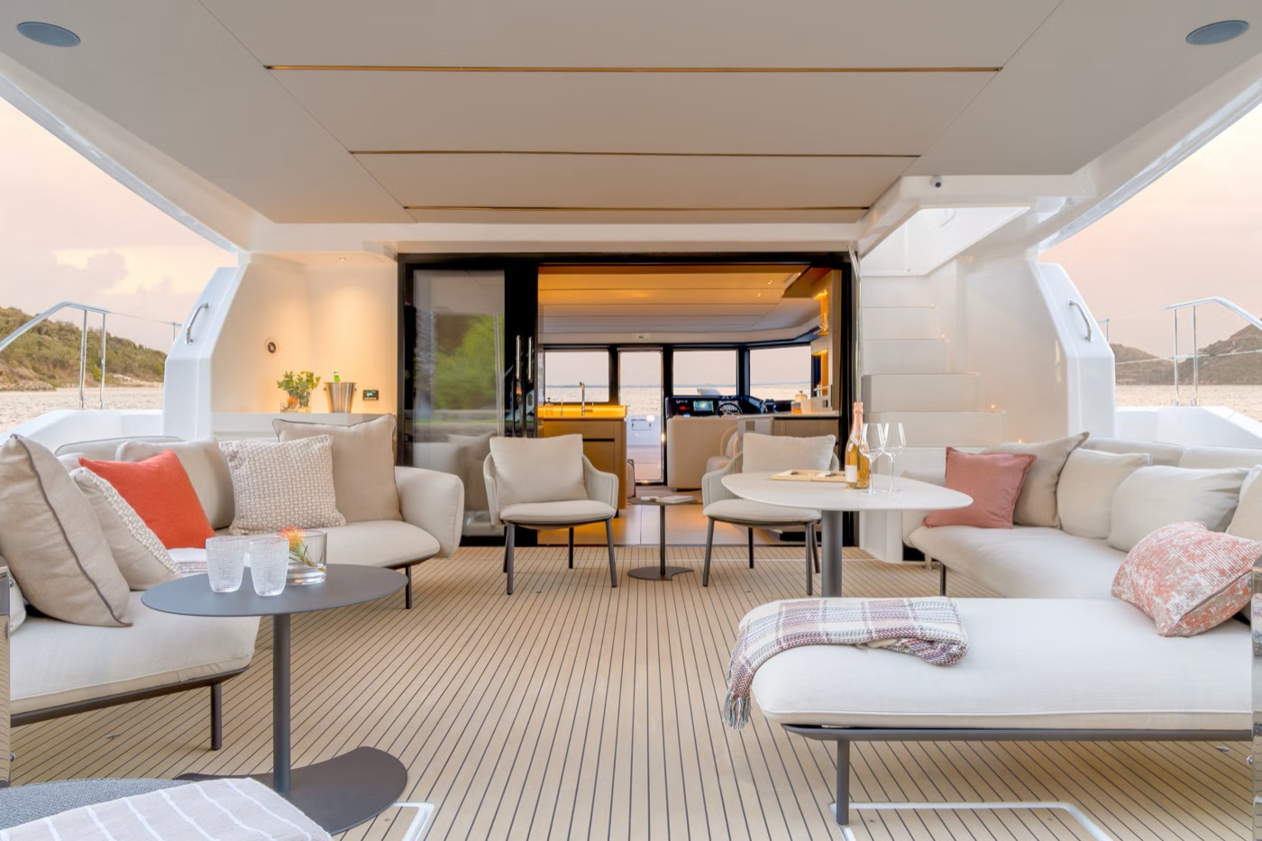 The 53PC cockpit at dusk, its wraparound sofas and daybeds glowing in warm light
