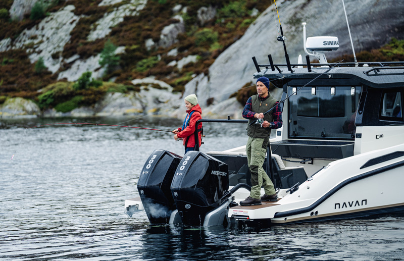 Two people fishing from the C30 aft deck, twin Mercury outboards
