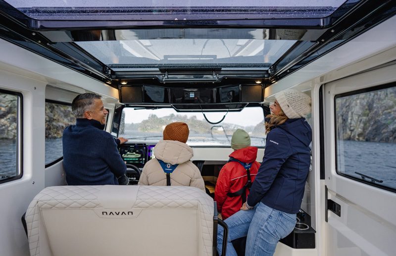Family gathered in the enclosed pilot house beneath a wide glass skylight
